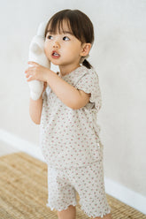 Toddler wearing Avauma Mellow Days Set in Berry Cream, holding a white plush bunny to her cheek